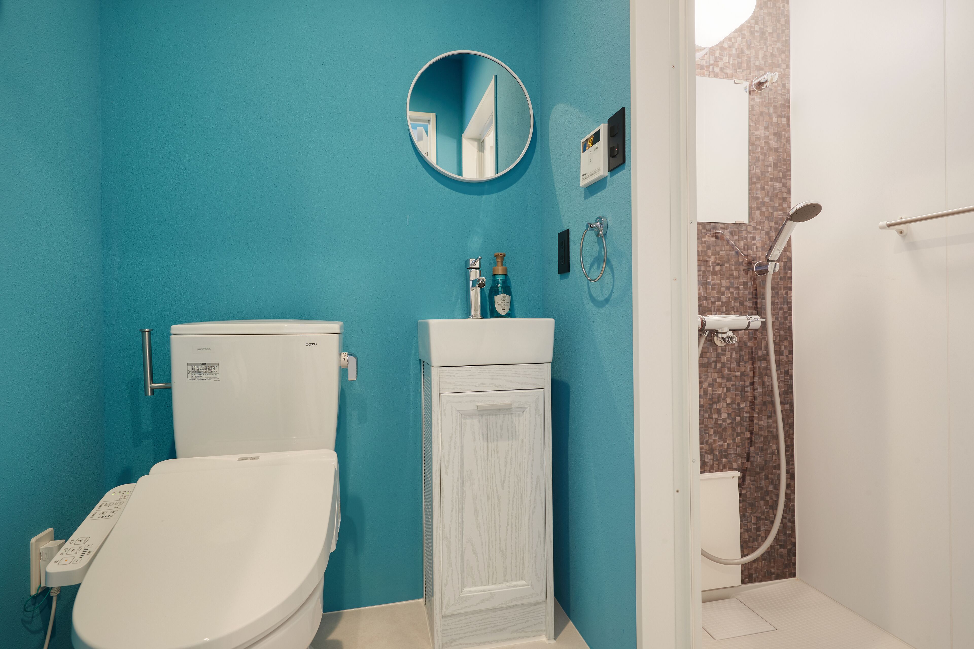 Une salle de bain comprenant des toilettes, un lavabo et une douche.