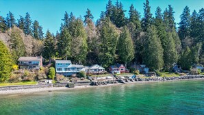 A waterfront property with multiple houses, a dock, and a rocky shoreline.