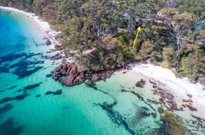 An aerial view of a coastal area with a beach, clear turquoise waters, and dense forest. - *Direct Access to Orion Beach* Jervis Bay Beachfront (Vincentia)
