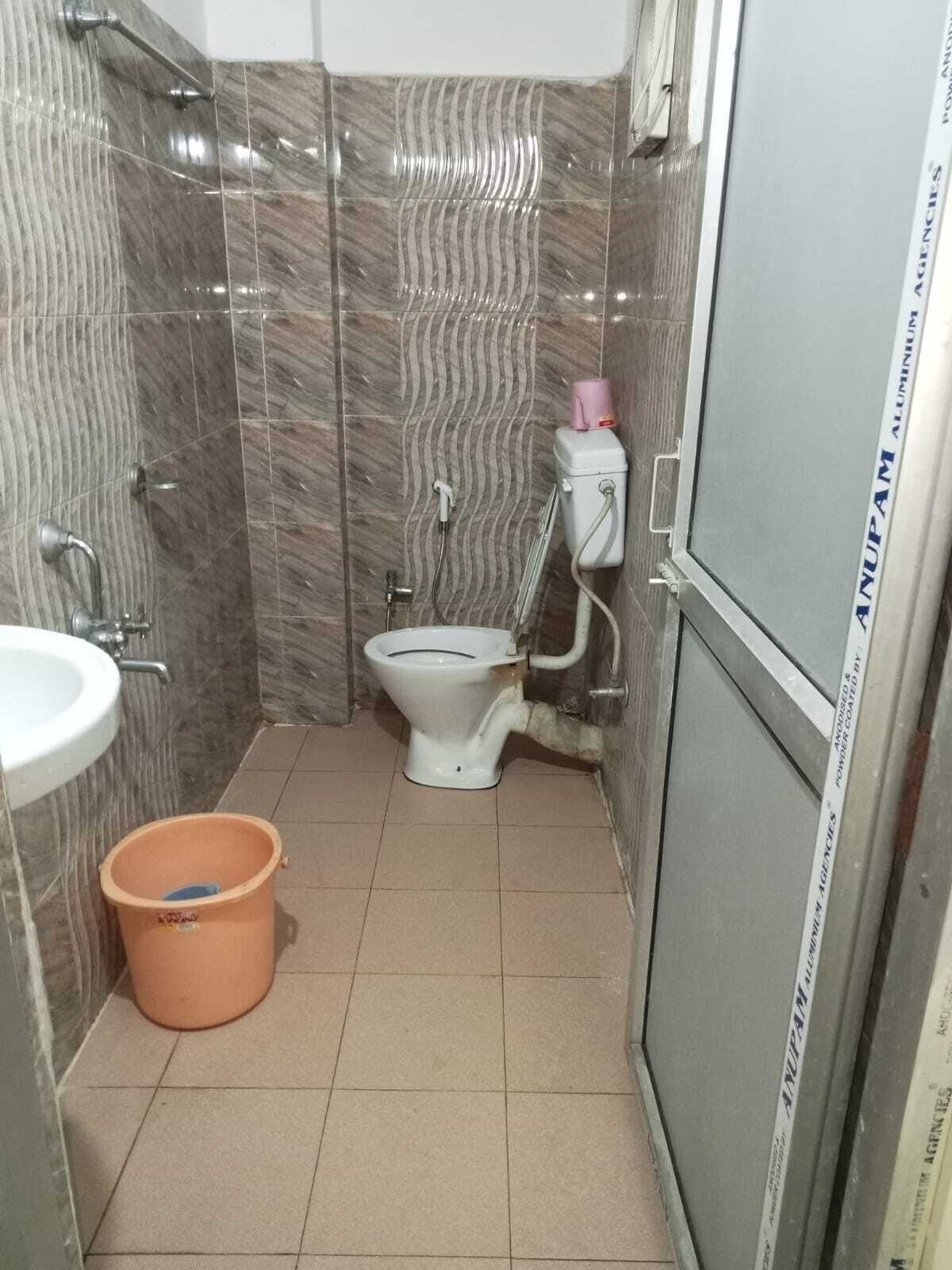 Un baño pequeño con inodoro, lavabo y ducha.