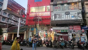 A red building with a sign reading "Hotel Tezpur City".