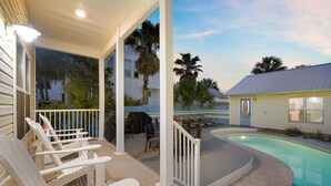 A covered outdoor area with a pool, lounge chairs, and a barbecue grill. - Flirty Flamingo- Pet-Friendly Vacation Home Near Beach with Private Pool Area (Destin)