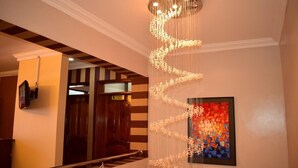 Un escalier agrémenté d’un luminaire moderne et d’un tableau abstrait aux couleurs vives.