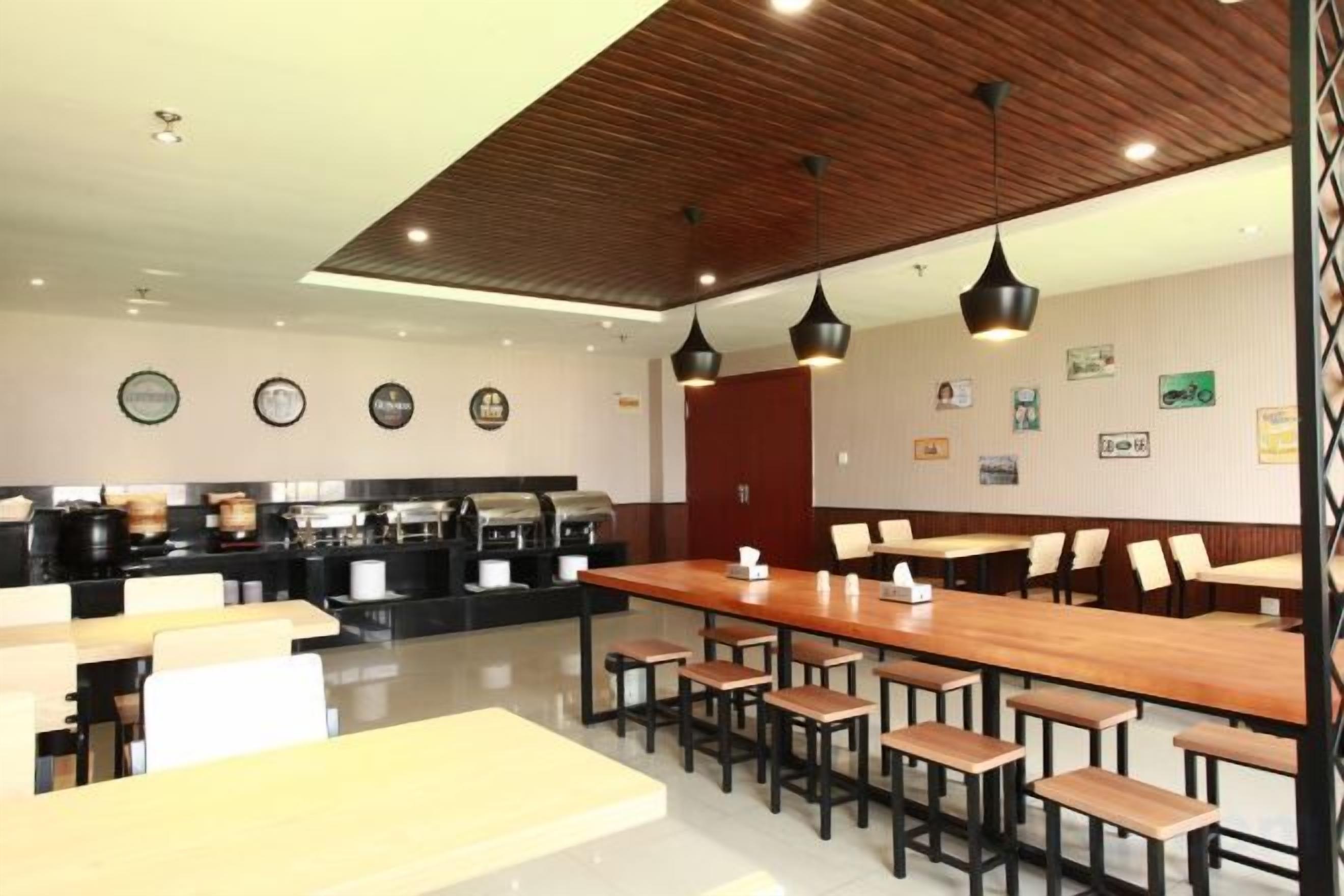 A modern restaurant with wooden tables and chairs, a bar area, and wall decorations.