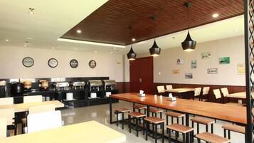 A modern restaurant with wooden tables and chairs, a bar area, and wall decorations.