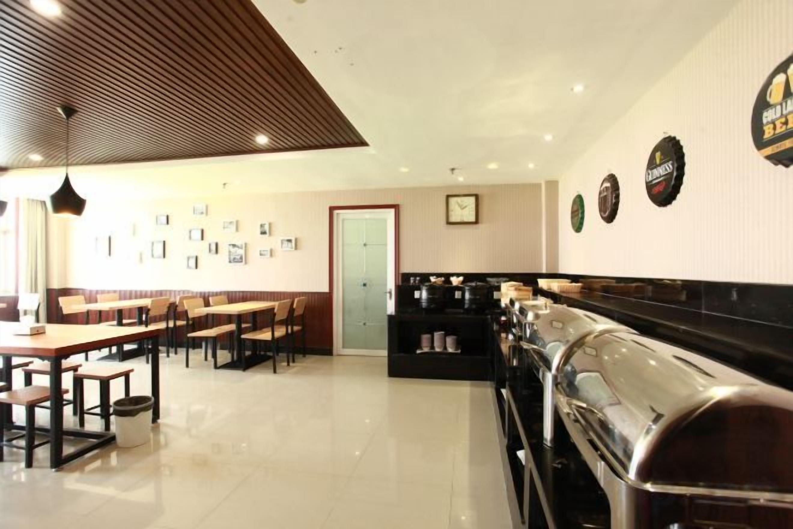 A cafe with tables and chairs, a coffee machine, and wall decorations.