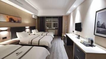 A hotel room with two beds, a desk, a TV, and a window.