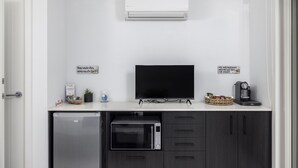 A compact kitchenette with a built-in microwave, oven, and coffee maker.