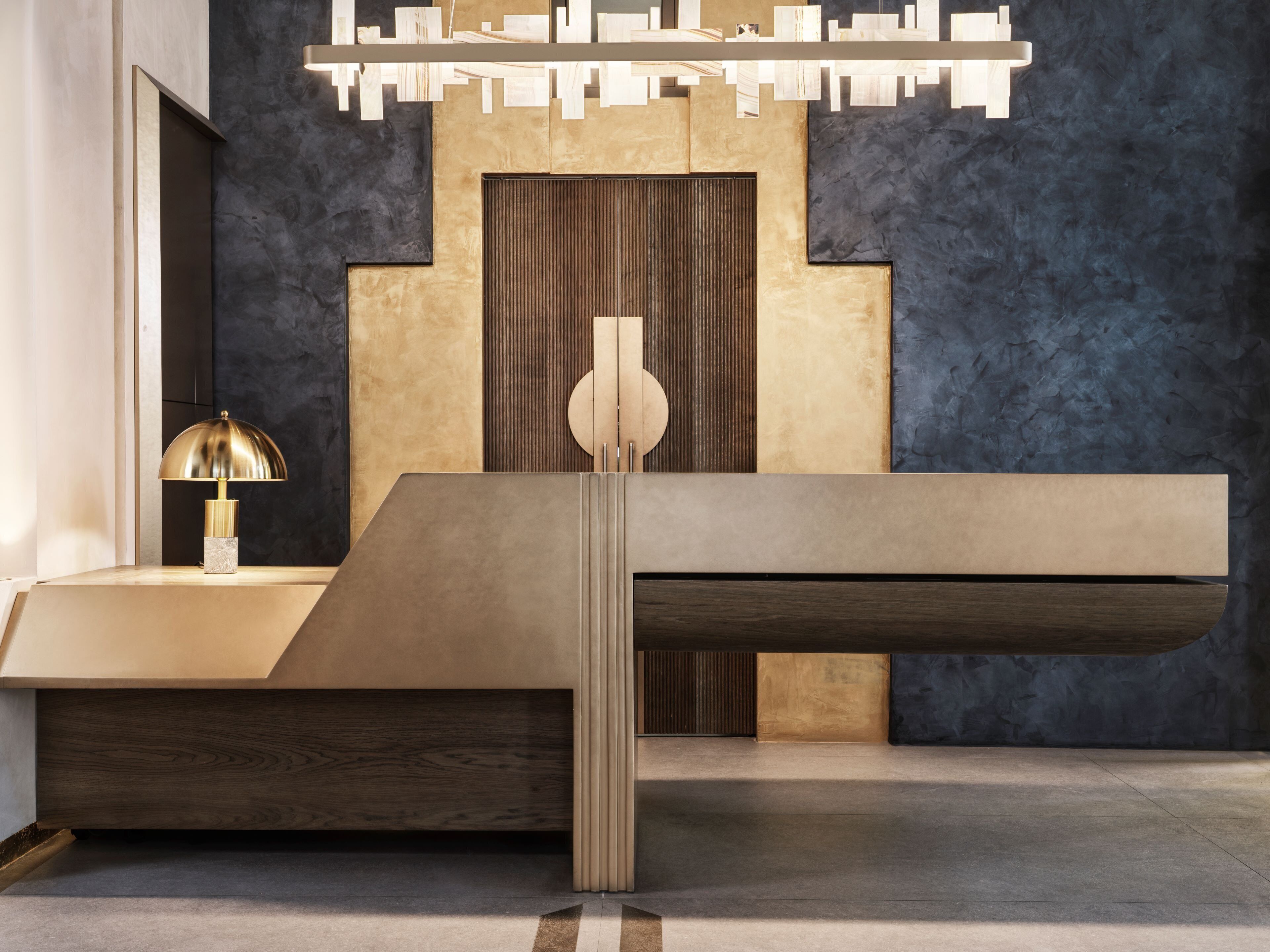 A modern interior with a minimalist design, featuring a central console table, a decorative lamp, and a unique wall paneling.
