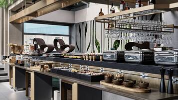 A modern bar area with a variety of glassware, bottles, and food items.