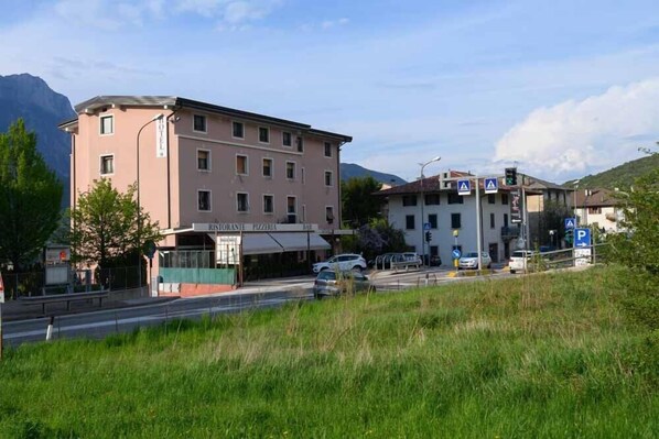 Un edificio con un letrero que dice "Ristorante Pizzeria Bar" y un cartel de estacionamiento que indica una zona de aparcamiento.