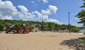 Un terrain de beach-volley avec une structure de jeu en bois et un filet.