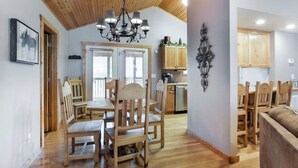Uma área de refeições acolhedora com mobiliário de madeira e um candelabro.