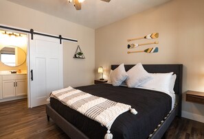 Cozy retreat with a large bed, sliding door to the bathroom, and a bedside table with a lamp.