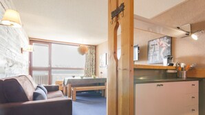 A cozy room with a sofa, a dining table, and a kitchenette.
