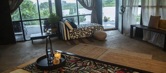 CABIN LOCATED ON A HILL NEXT TO THE FOREST WITH A VIEW OF THE LAKE