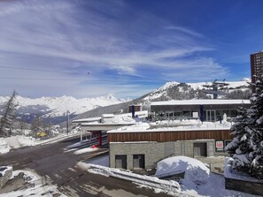 Ein Hotel mit einer Seilbahn im Hintergrund, umgeben von schneebedeckten Bergen.