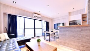 Un salon moderne comprenant un canapé, une table basse et un coin repas avec une table et des chaises.