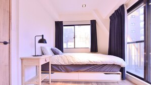 Une chambre à coucher avec un lit, un bureau et une fenêtre.