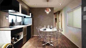 Una cocina moderna con comedor, que presenta una mesa redonda con sillas, iluminación colgante y vistas de la habitación contigua.