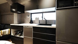 Una cocina moderna con microondas integrado, electrodomésticos de acero inoxidable y una ventana sobre el lavamanos.