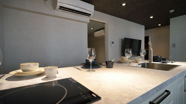 A modern kitchen with a built-in oven, a sink, and a flat-screen TV mounted on the wall. - Real Life AOYAMA 2BR suite 5pax 3bed 3min metro (Minato)