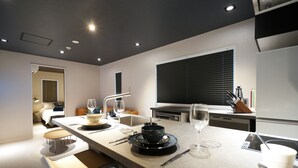 Een moderne keuken met een centraal eiland, een zithoek met banken en uitzicht op de woonkamer.