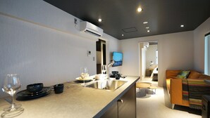 Een moderne keuken met een groot eiland, een ingebouwde oven en een flatscreen televisie.