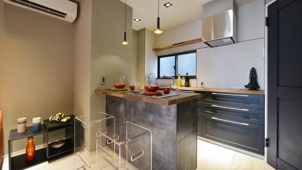 A modern kitchen with a central island, stainless steel appliances, and pendant lighting.