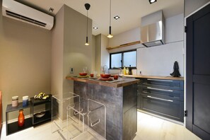 A modern kitchen with a central island, stainless steel appliances, and pendant lighting. - Real Life Meguro River Fancy 1BR 4Pax Shibuya (Setagaya)