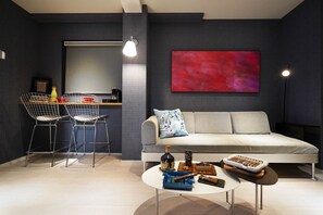 Un salon moderne comprenant un canapé, une table basse et un coin repas avec des chaises et une table.