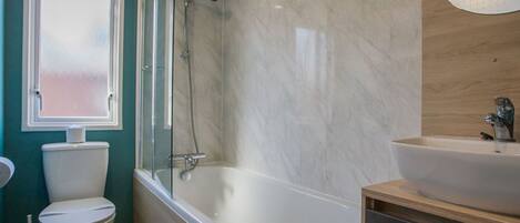 Ein Badezimmer mit Toilette, Badewanne und Waschbecken.
