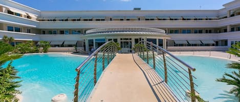 Ein Hotel mit zentralem Pool, einer überdachten Galerie und einem mehrstöckigen Gebäude.