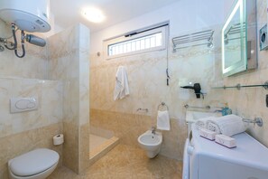 A bathroom with a toilet, bidet, shower, and a sink with a glass enclosure. - Rivoltella Apt With Pool 600m From Lake (Desenzano del Garda)