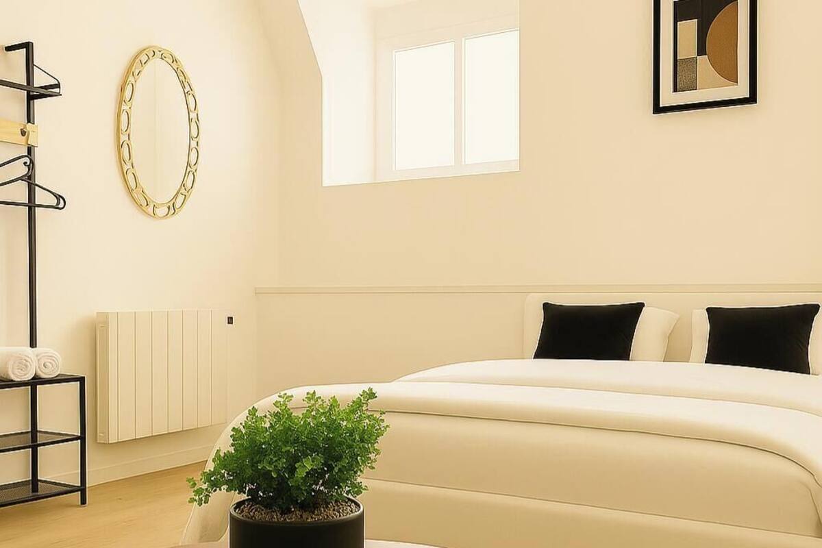 A modern living room with a round table, a sofa, and a potted plant.