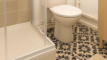 A bathroom with a shower, toilet, and sink.