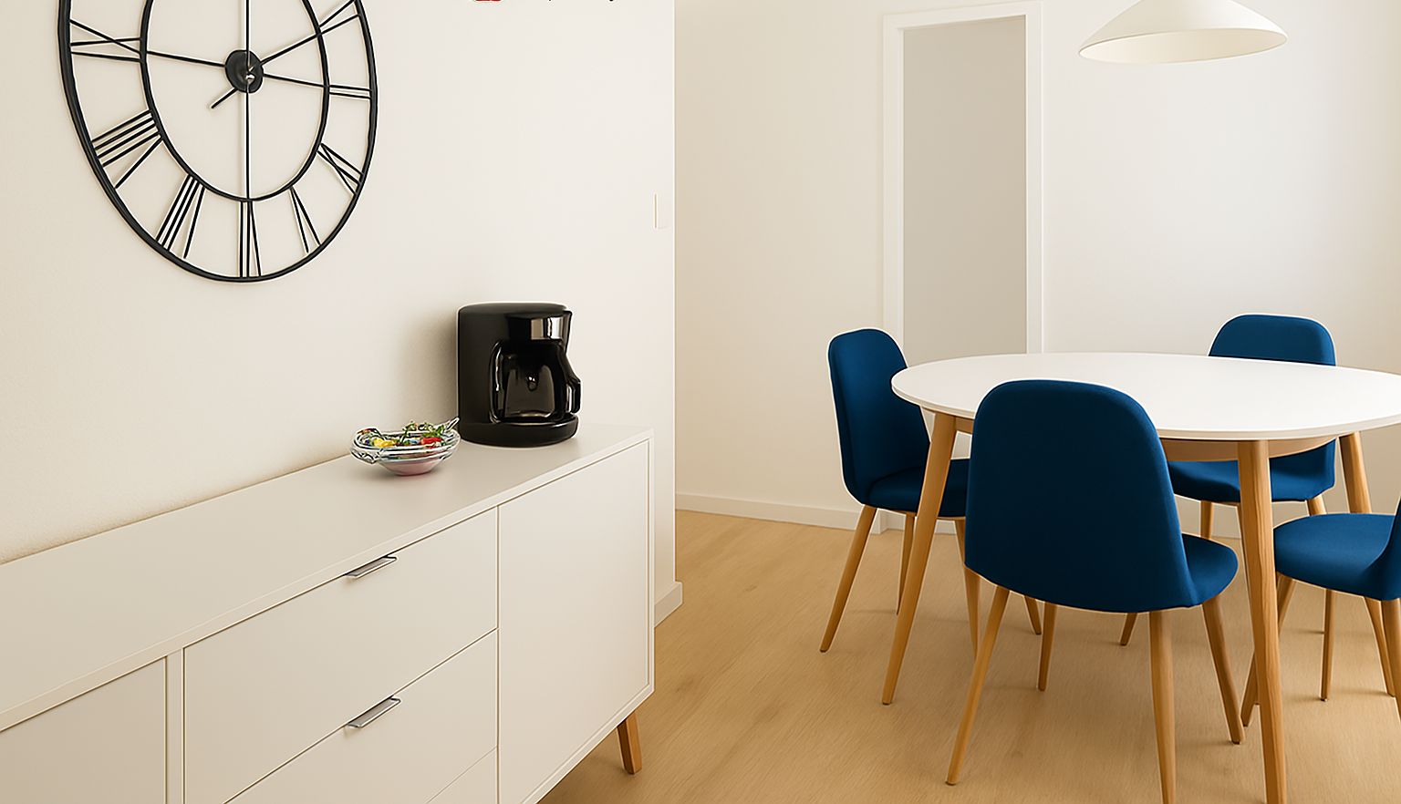 Un espace repas moderne avec une table ronde, des chaises bleues, une machine à café et une grande horloge murale.