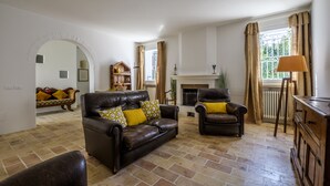 A living room with a fireplace, leather sofas, and a wooden cabinet. - Pimpotta House (Ravenna)