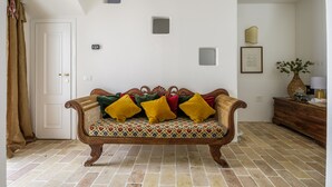 A room with a patterned sofa, a wooden cabinet, and a door. - Pimpotta House (Ravenna)