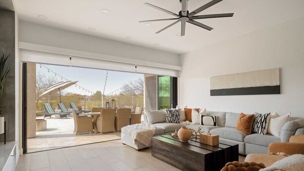 A spacious living room with a large sofa, a coffee table, and a view of an outdoor patio area. - Breathtaking Wildfire Golf Views | Pool (Phoenix)