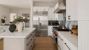 A modern kitchen with white cabinetry, stainless steel appliances, and a marble countertop. - Breathtaking Wildfire Golf Views | Pool (Phoenix)