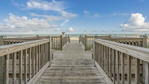 A wooden boardwalk leading to a beach with a clear sky. - Turtle Cove, Spectacular Ocean Front 1 bedroom! (Myrtle Beach)