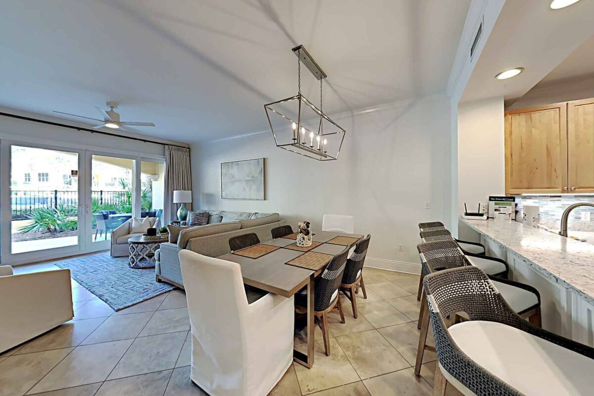 A modern open-plan living area with a dining table, sofa, and chairs.