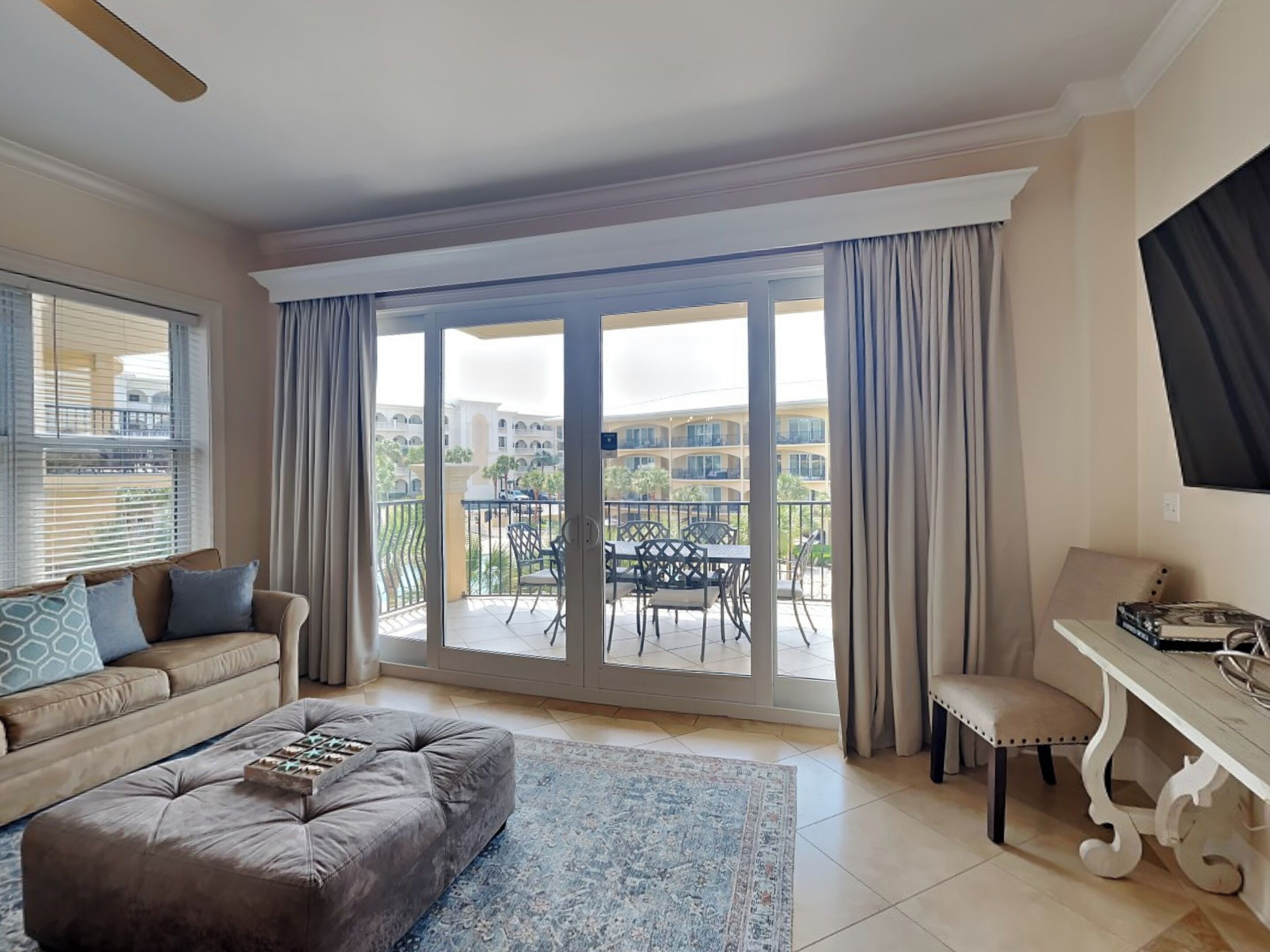 Una sala de estar con sofá, reposapiés y una zona de comedor con mesa y sillas.