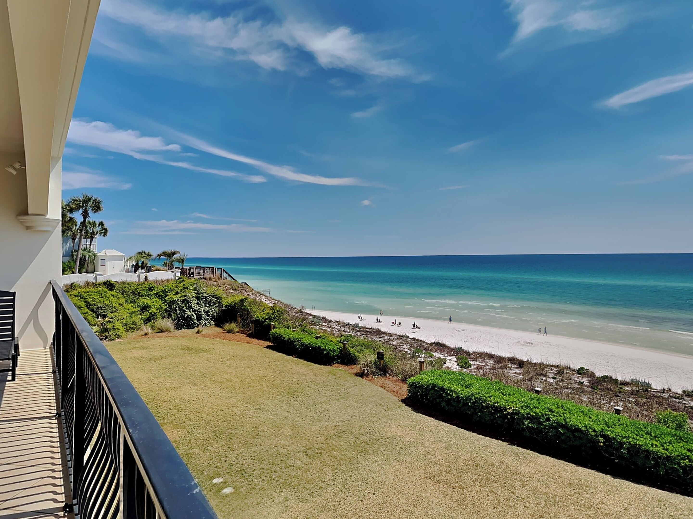A balcony with a view of a beach and ocean.