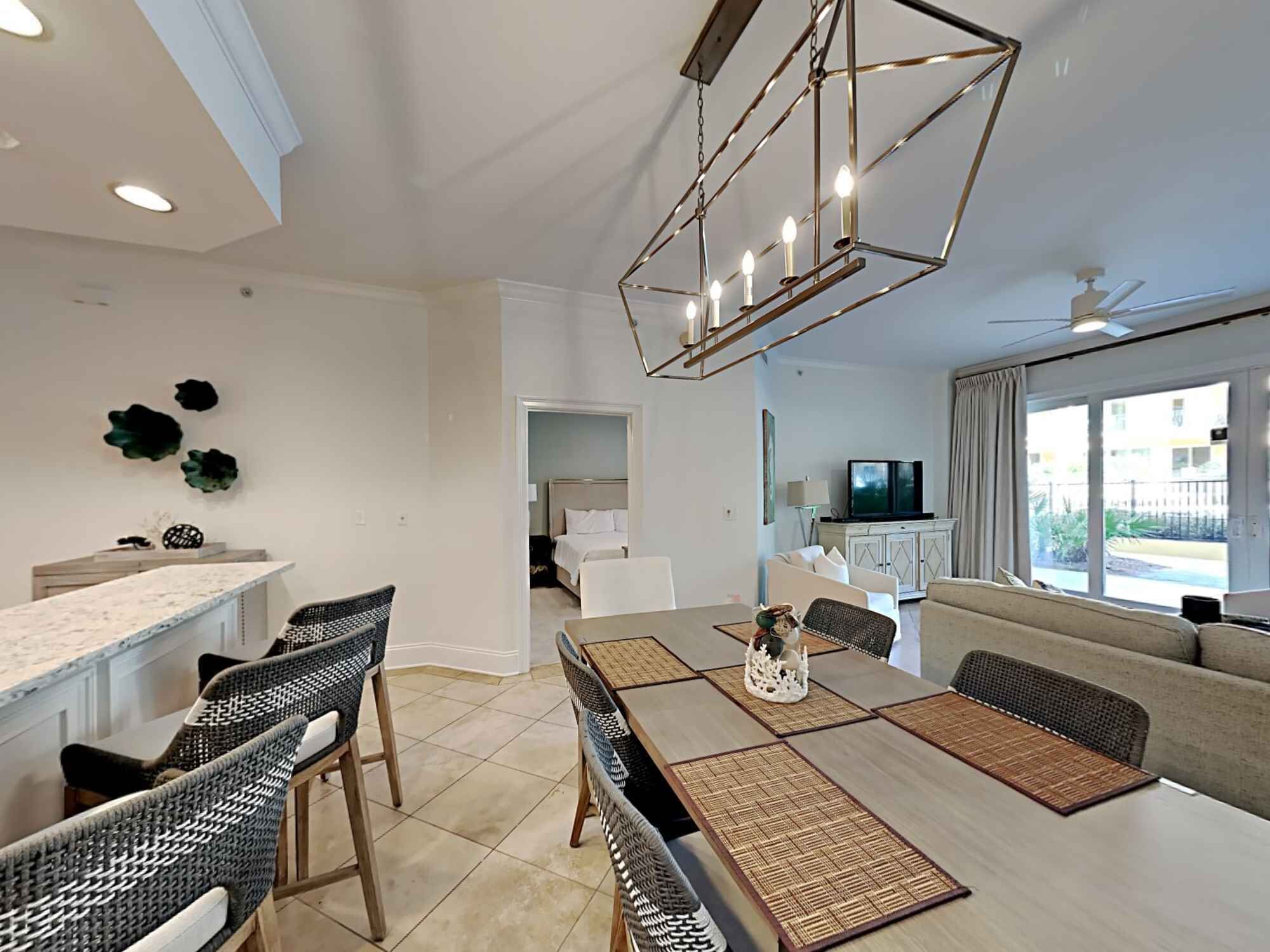 A modern living room with a dining area, a kitchen, and a bedroom.