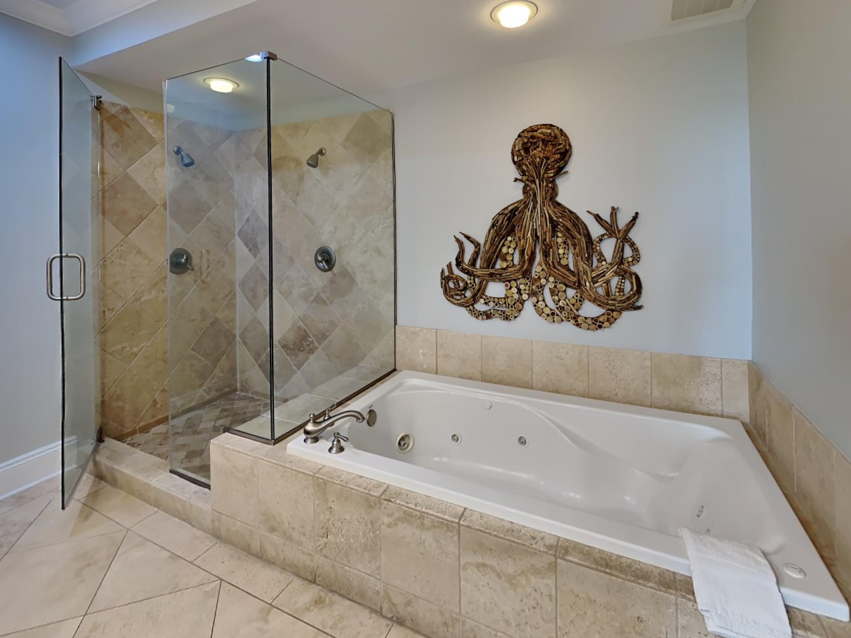 A modern bathroom with a glass-enclosed shower, a freestanding bathtub, and a decorative wall piece.