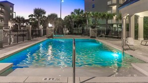 A swimming pool with a 3 ft depth marker, surrounded by palm trees and a building with balconies. - Alerio by Southern Vacation Rentals (Miramar Beach)