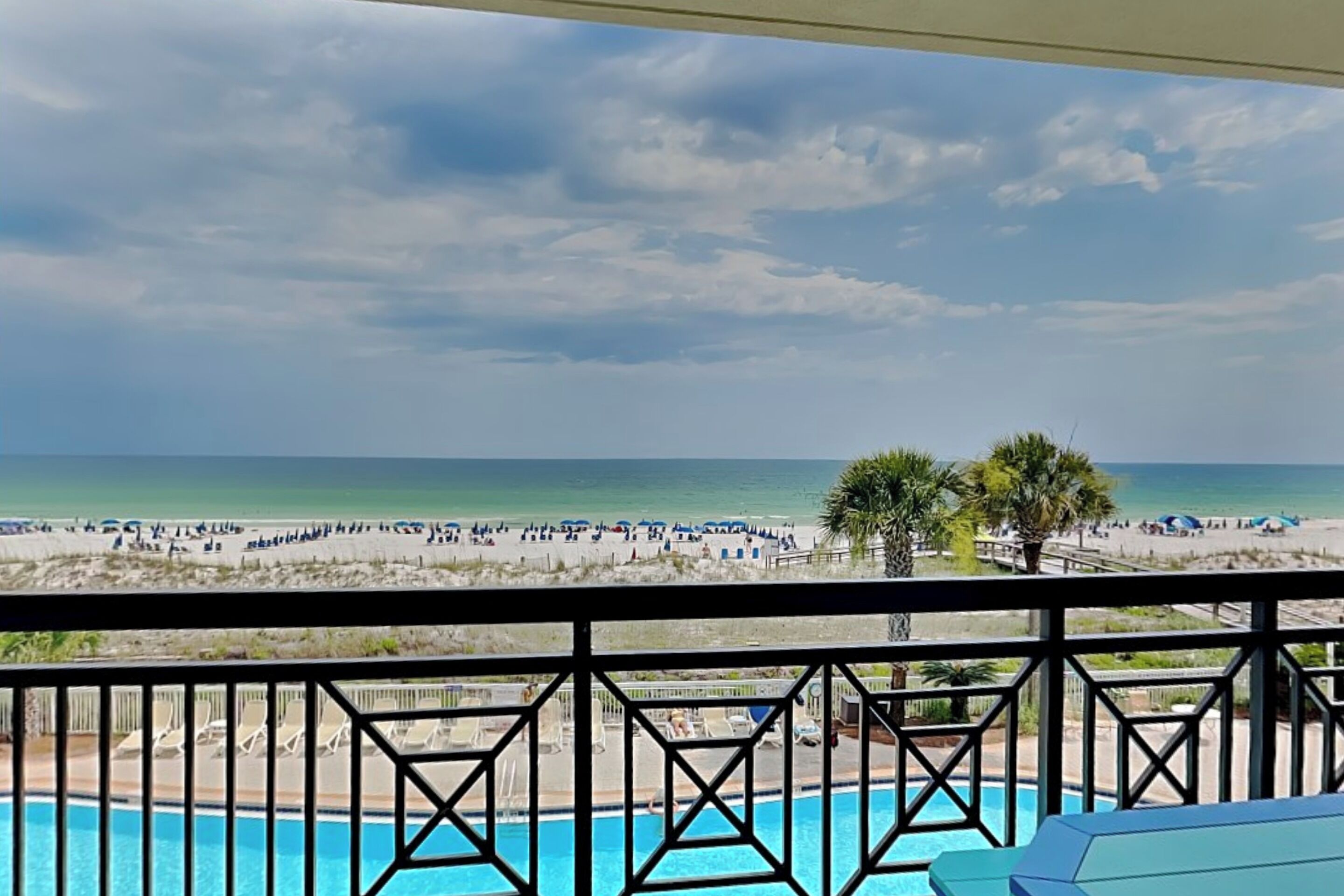 A poolside view with a beach in the background.