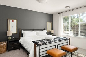 Cozy retreat with a bed, nightstand, and bench, offering a comfortable space to rest.